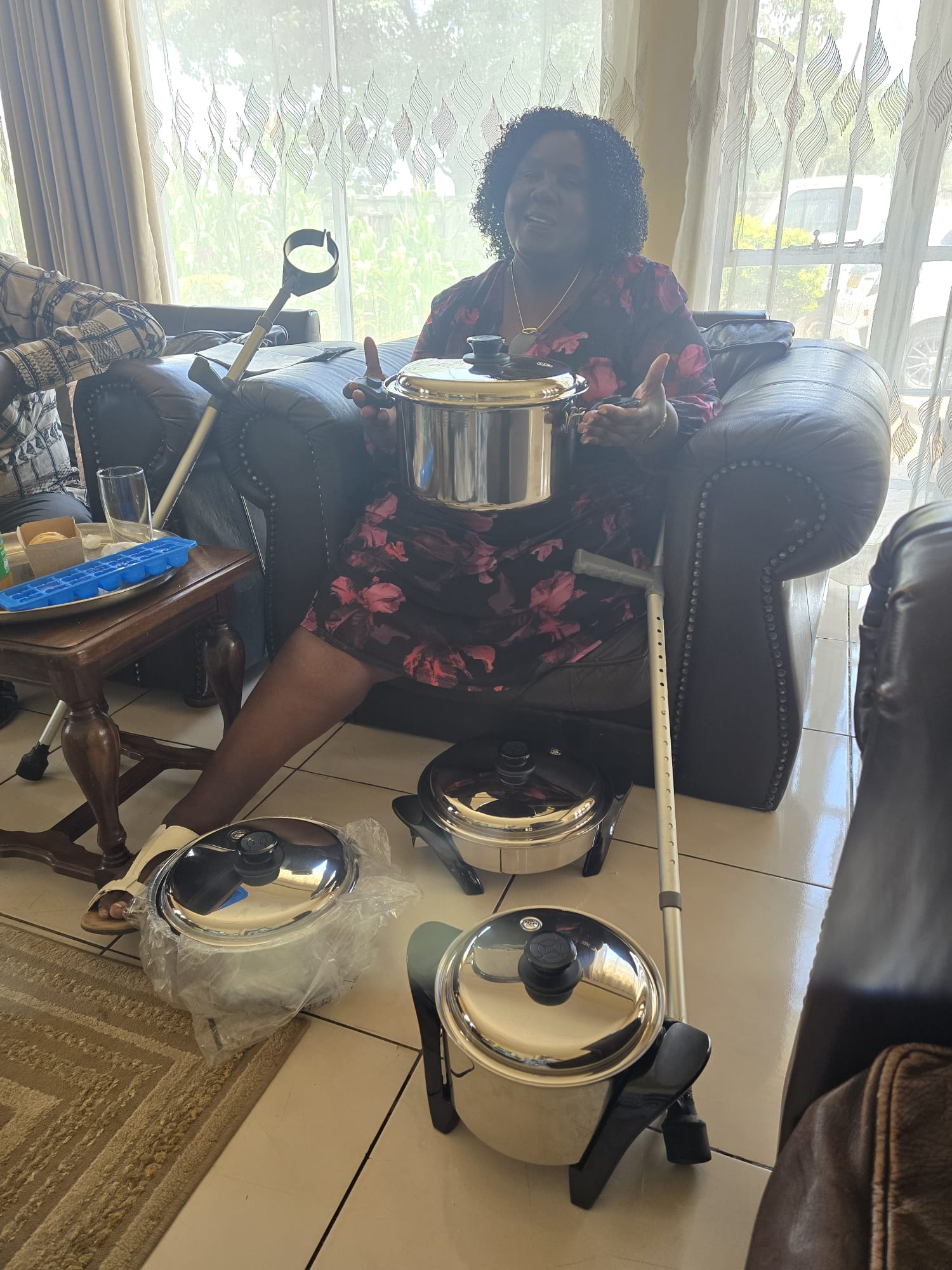 Happy customer at home surrounded by her new Saladmaster stainless steel cookware set