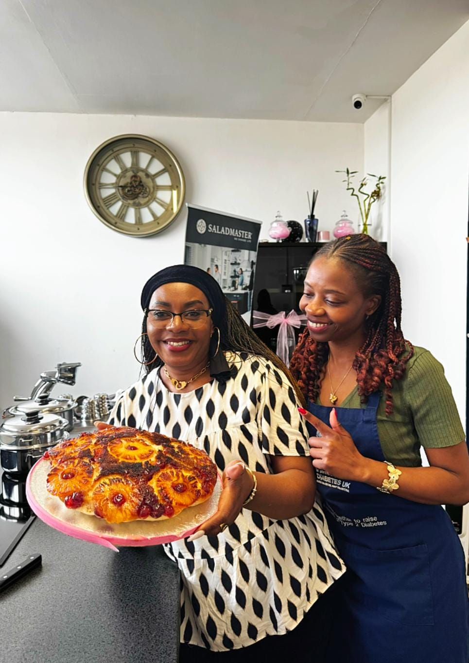 Guest and host smiling with a freshly baked pineapple upside-down cake at the Saladmaster Leeds studio