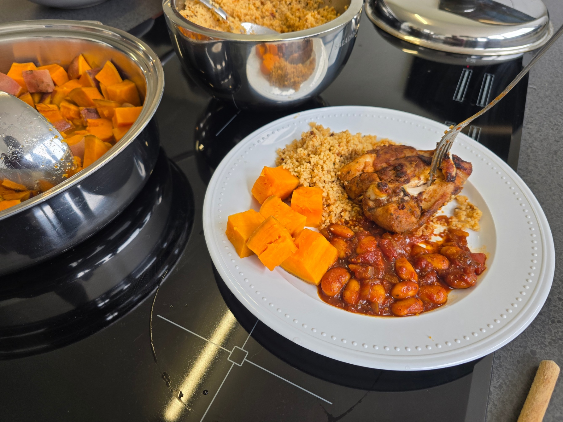 Plated healthy meal beside Saladmaster cookware on the hob