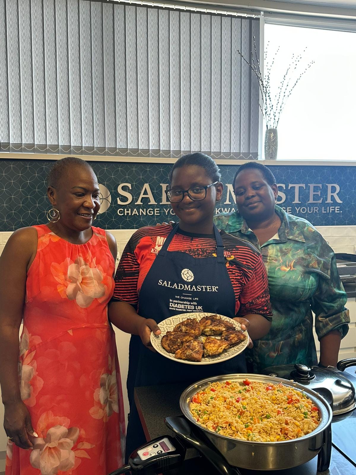 Team presenting freshly cooked jollof rice and BBQ chicken at the Saladmaster Diabetes UK studio