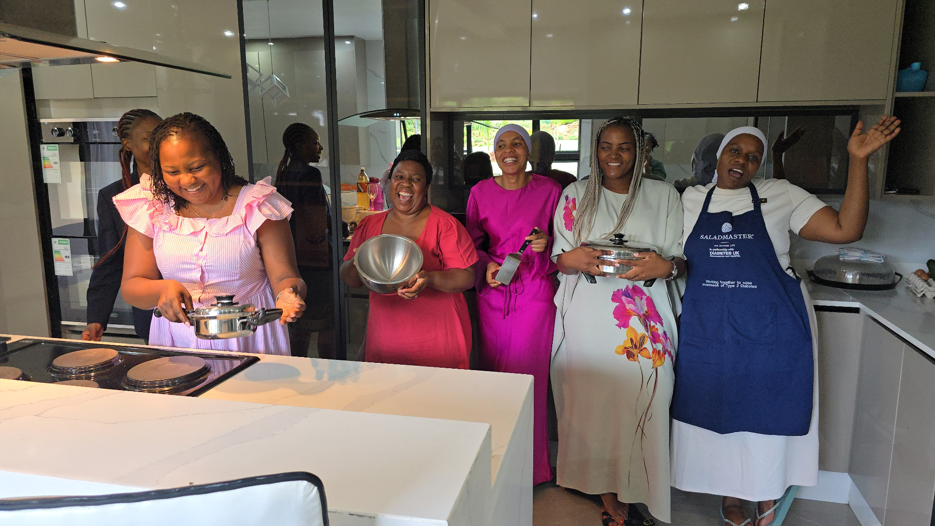 Group of women celebrating in a modern kitchen with Saladmaster cookware