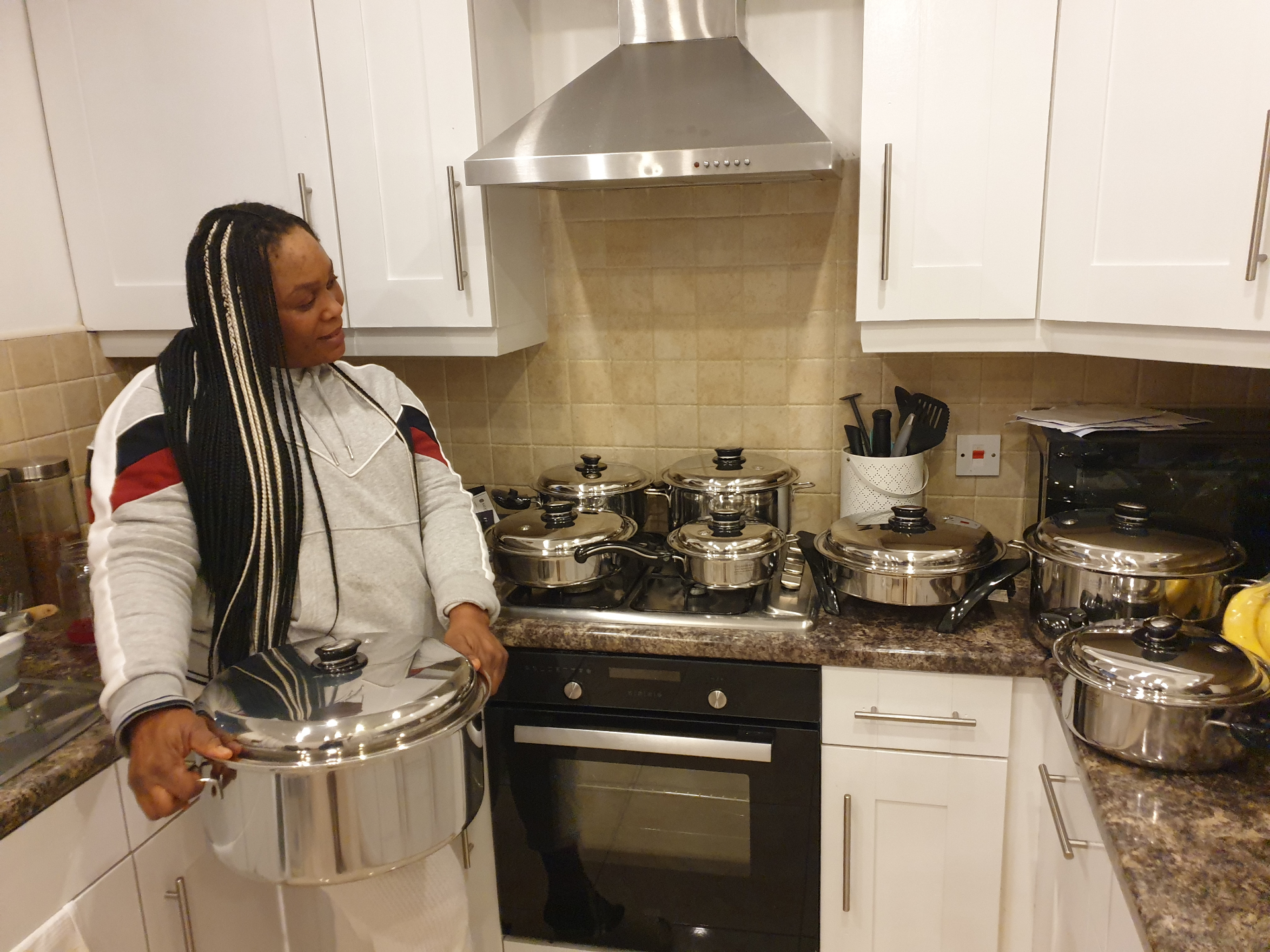 Founder presenting a full Saladmaster cookware display in a home kitchen